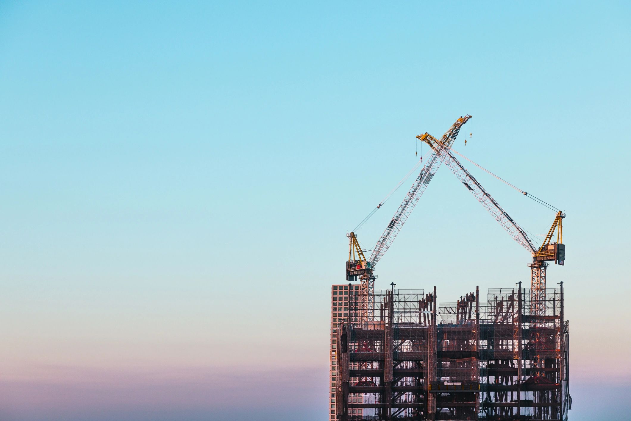 Construction site with high-rise steel framework and tower cranes